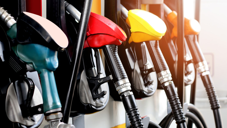 주유소의 다양한 색상의 주유 펌프가 가까이 표시됩니다.