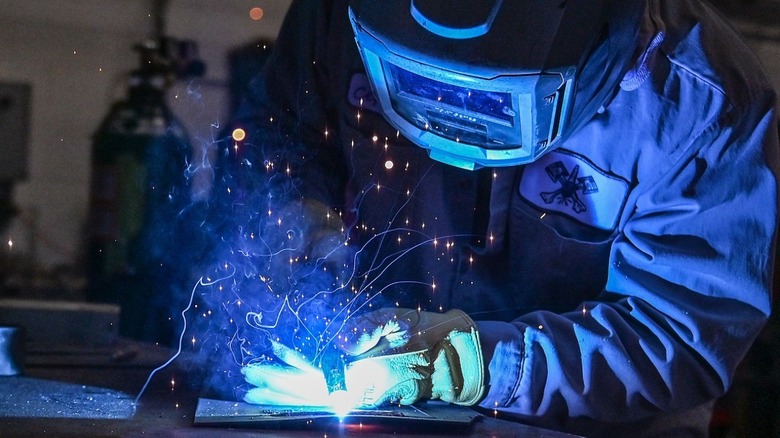 금속 조각을 용접하는 기계공.
