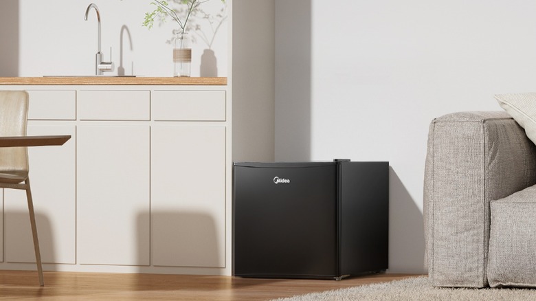 거실 벽 옆에 있는 Midea 냉장고.