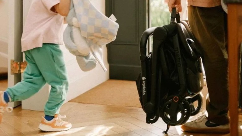 접힌 ErgoBaby Metro 3 경량 유모차를 들고 있는 남성