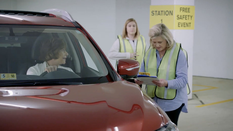CarFit 자원봉사자가 고령 운전자를 교육하고 있습니다.