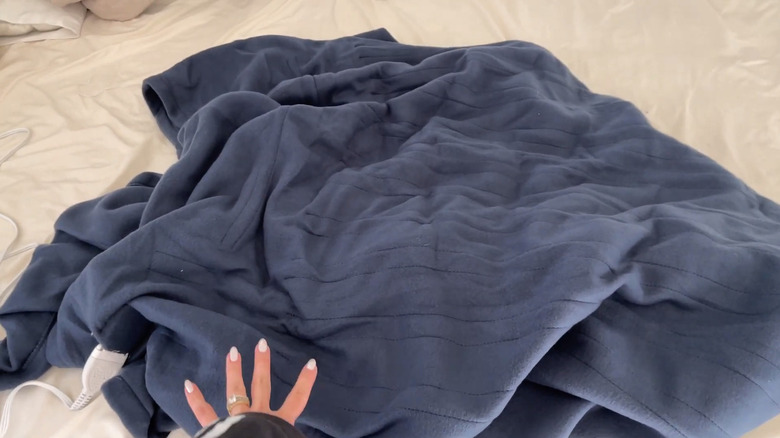 침대 위에 Sunbeam 전기 온열 침대 담요의 사진입니다.