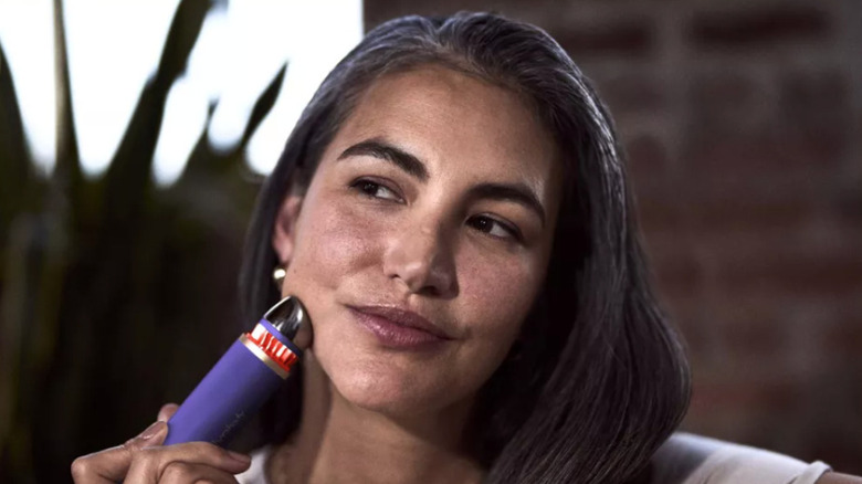 여성의 얼굴에 사용되는 Therabody의 TheraFace 장치