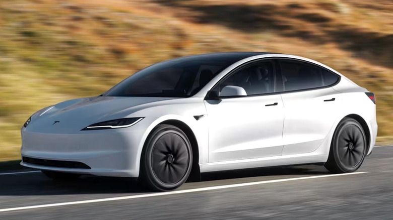 시골 도로를 주행하는 흰색 Tesla Model 3