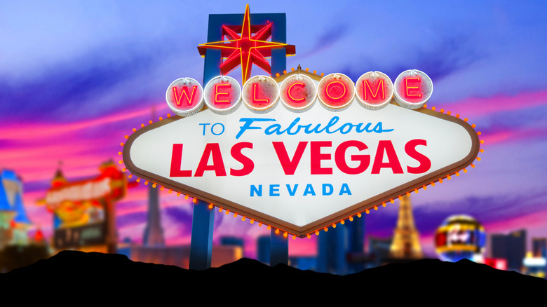 황혼 무렵에 켜진 라스베가스 간판과 그 뒤에 조명이 켜진 스트립