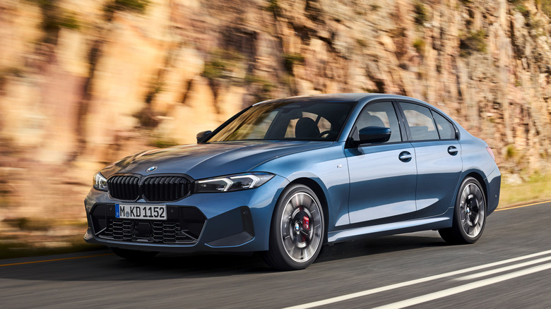 협곡 도로를 주행하는 파란색 BMW 3 시리즈의 전면 3/4 뷰.