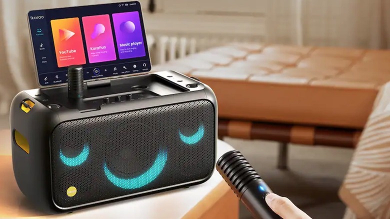 이카라오 노래방 기계에 마이크를 연결하는 사람