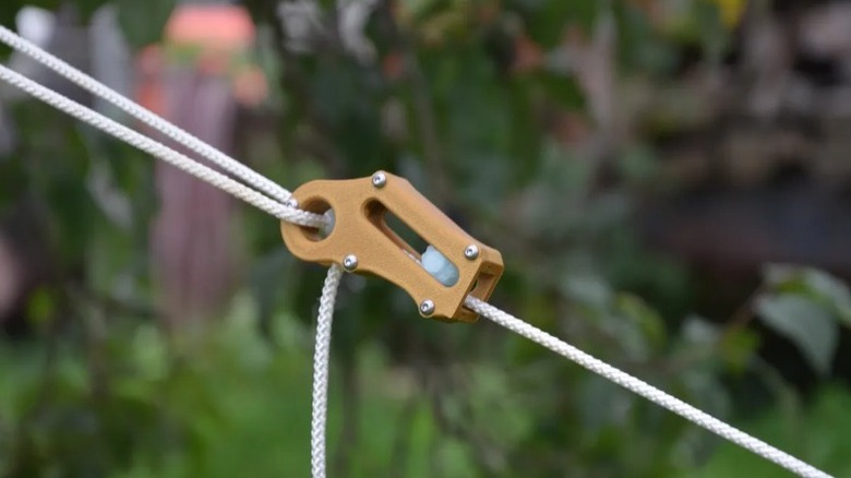 흰색 파라코드를 들고 있는 자동 파라코드 로프 텐셔너