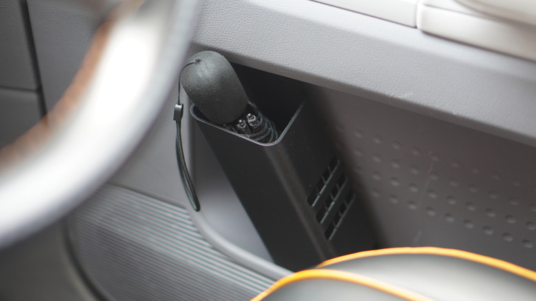 자동차 앞문 주머니 안에 3D 프린팅된 우산 꽂이가 있습니다.