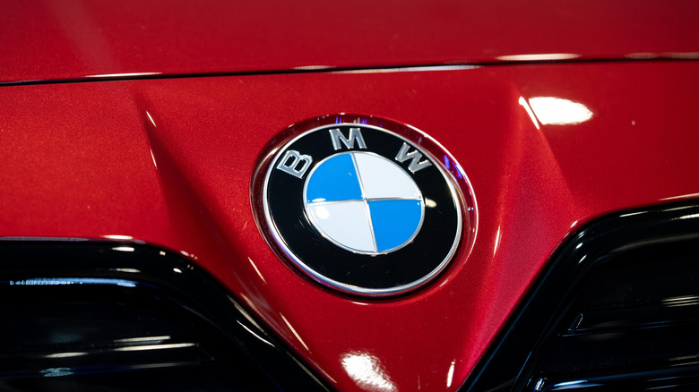 빨간색 BMW 전면 범퍼와 후드 부분에 있는 BMW 배지 클로즈업.