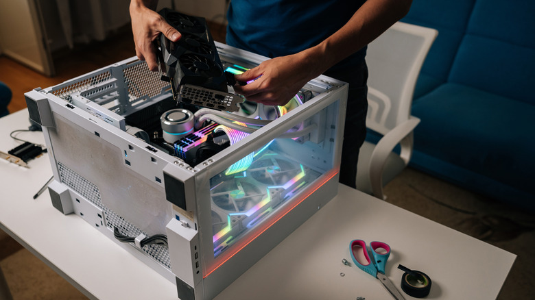 기술자가 데스크탑 PC 내부에 그래픽 카드를 설치하고 있습니다.