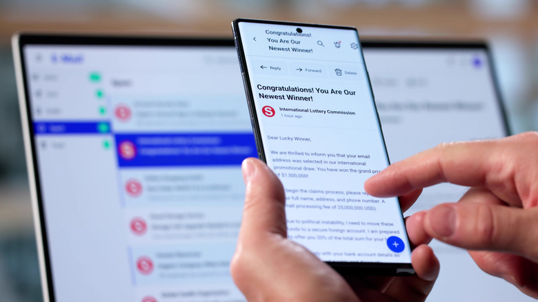 한 남성이 구형 스마트폰으로 사기 이메일 경고를 받았습니다.