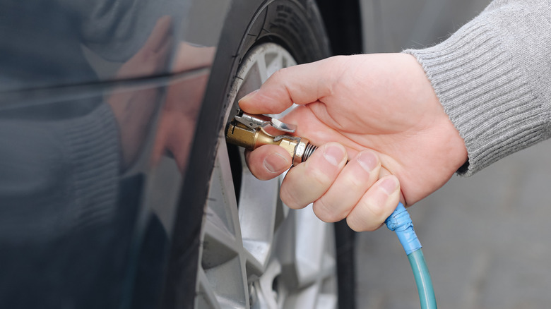 공기 압축기로 자동차 타이어에 공기를 주입합니다.