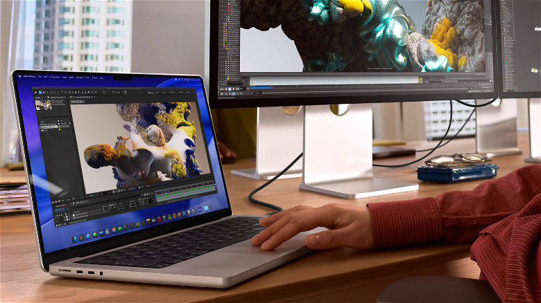 데스크탑 PC 옆 책상 위에서 사용 중인 MacBook Pro M5.