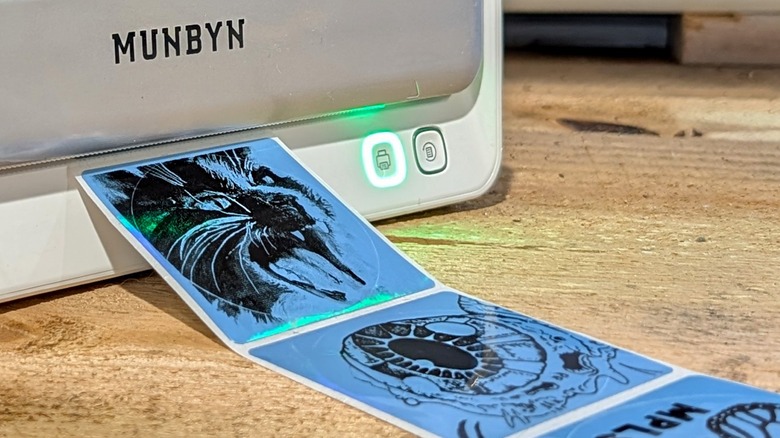 나무 표면에 여러 개의 스티커가 붙어 있는 Munbyn 프린터.