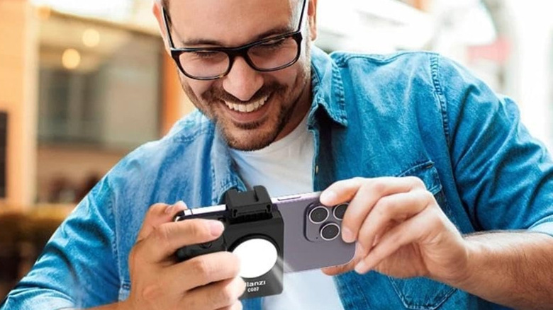 한 남자가 iPhone에서 Ulanzi Bluetooth 스마트폰 캡 그립을 사용하여 사진을 찍고 있습니다.