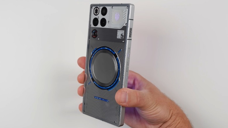 흰색 배경 앞에 RedMagic 11 Pro를 들고 있는 손