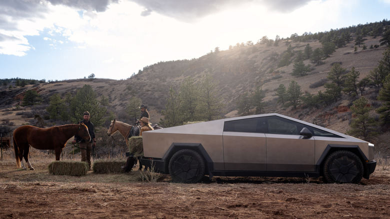 목장에 말과 함께 주차된 Tesla Cybertruck의 측면 모습.