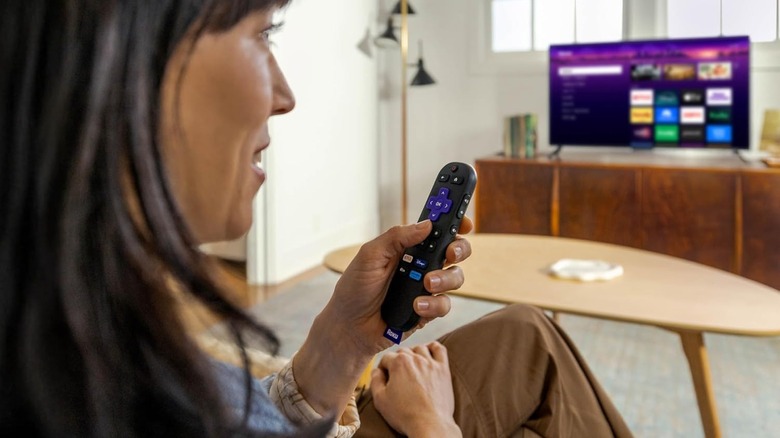 Roku 리모컨을 들고 있는 여자