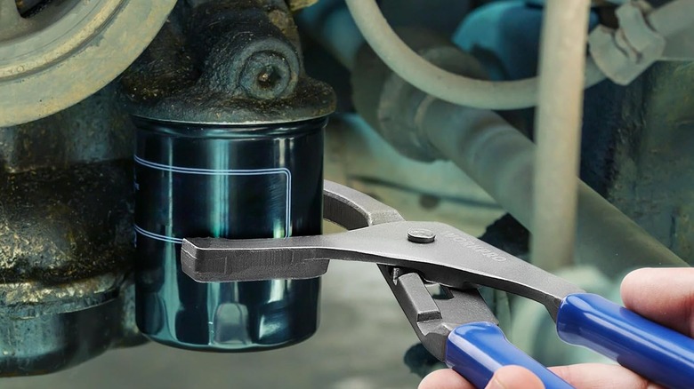 오일 필터 렌치를 사용하는 사람