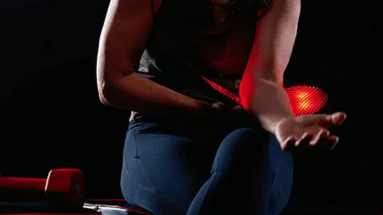 팔뚝에 빨간불 장치를 사용하는 여성