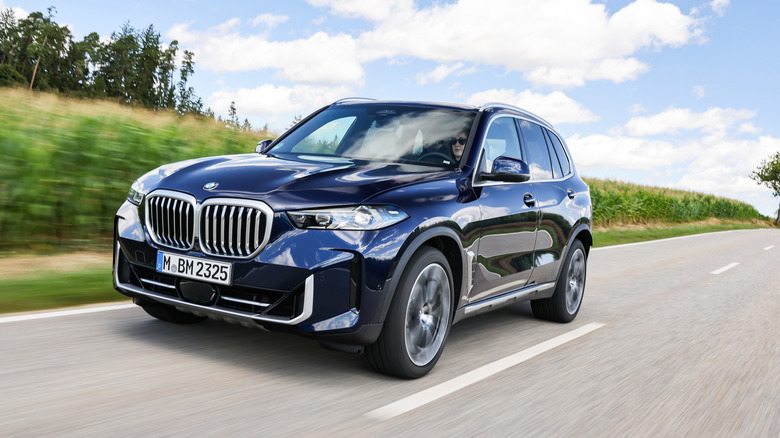 뒷길에 있는 매우 진한 파란색 페이스리프트 BMW X5의 전면 3/4 뷰