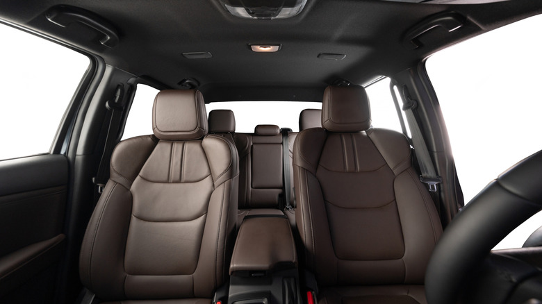 갈색 좌석과 검은색 실내 장식으로 뒤를 돌아보는 자동차의 내부 모습.