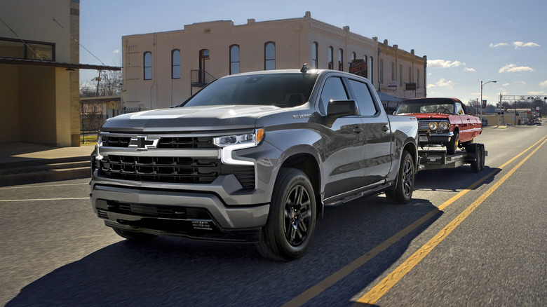 오래된 임팔라를 견인하는 쉐보레 실버라도 1500 RST