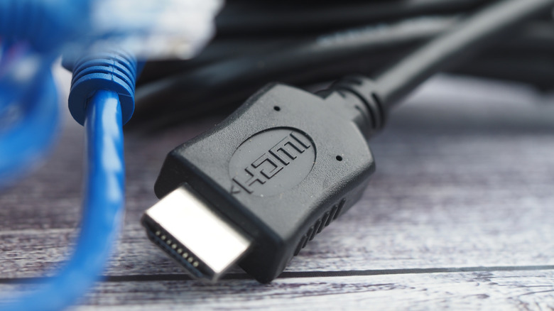 다양한 HDMI 케이블과 커넥터가 나무 테이블 위에 배열되어 있습니다.