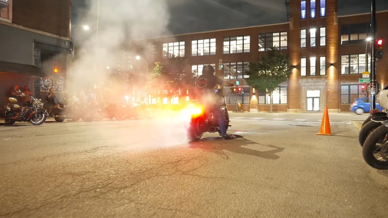 다른 사람들이 지켜보는 가운데 Motoblot에서 고무를 태우는 바이커
