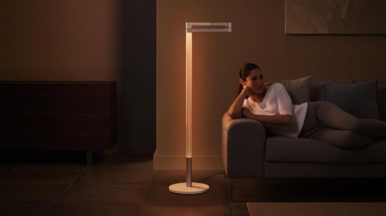 Dyson Solarcycle Morph 플로어 조명 옆 소파에 누워 있는 사람