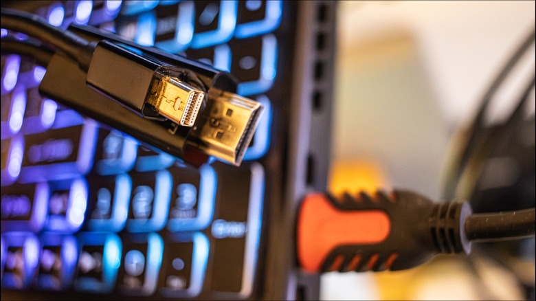 HDMI 케이블이 연결된 노트북 앞에 있는 미니 DP-HDMI 어댑터 케이블.