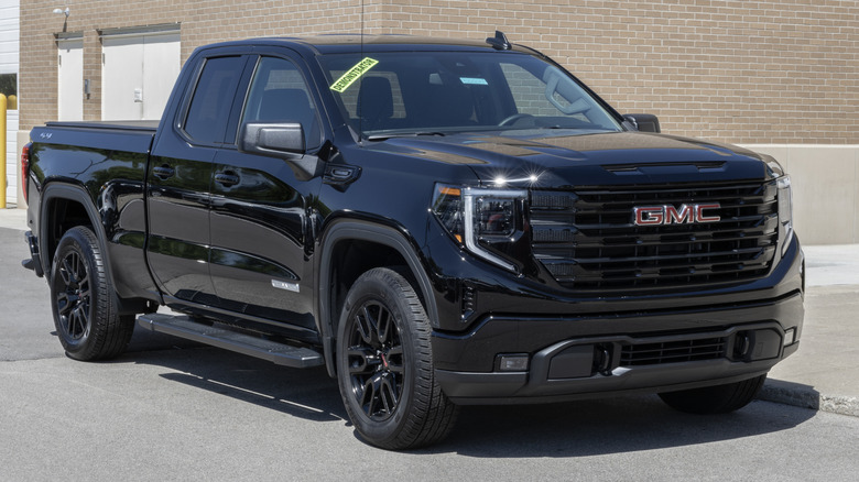 건물 앞에 주차된 Black GMC Sierra 1500 Elevation 3VL