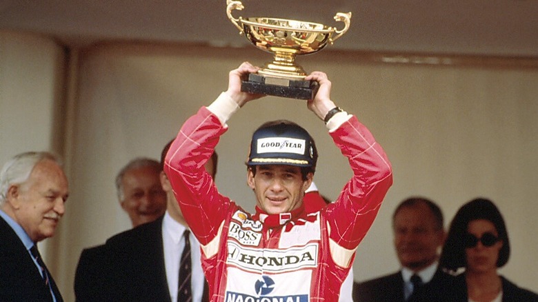 머리 위로 우승 트로피를 들고 모나코 연단에 있는 Ayrton Senna