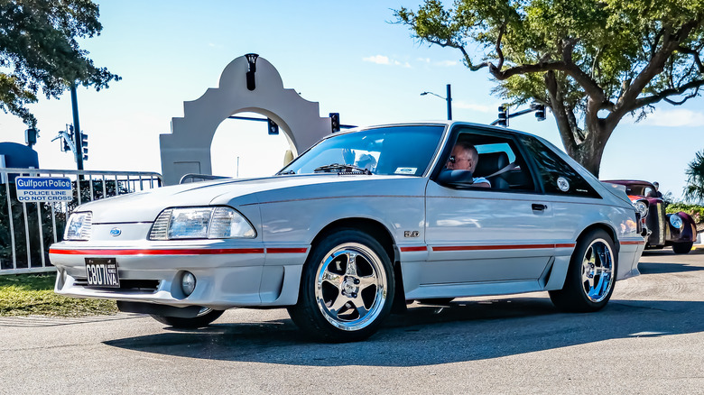 자동차 쇼에서 흰색과 빨간색 Fox Body Ford Mustang GT의 전면 3/4 뷰.