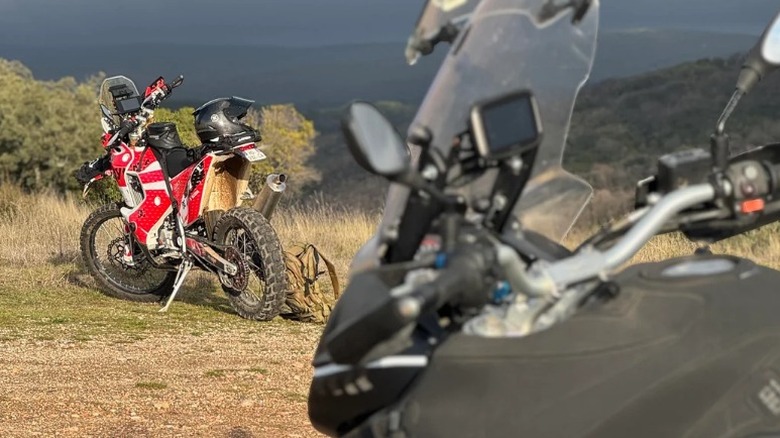 트레일에 주차된 모토구찌 Stelvio 1200과 그 앞에 먼지 자전거가 있습니다.