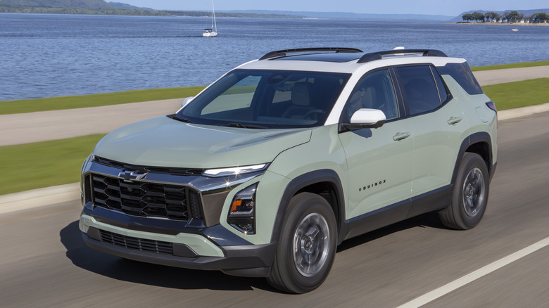 물과 범선을 배경으로 도로 위의 녹색 2026 Chevrolet Equinox