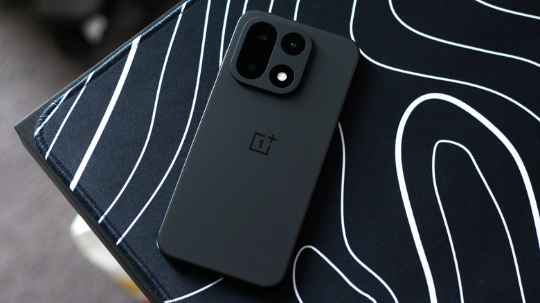 추상적인 흰색과 검은색 패턴이 있는 마우스 패드의 검은색 OnePlus 15.