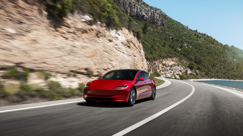 해안 도로를 달리는 빨간색 Tesla Model 3