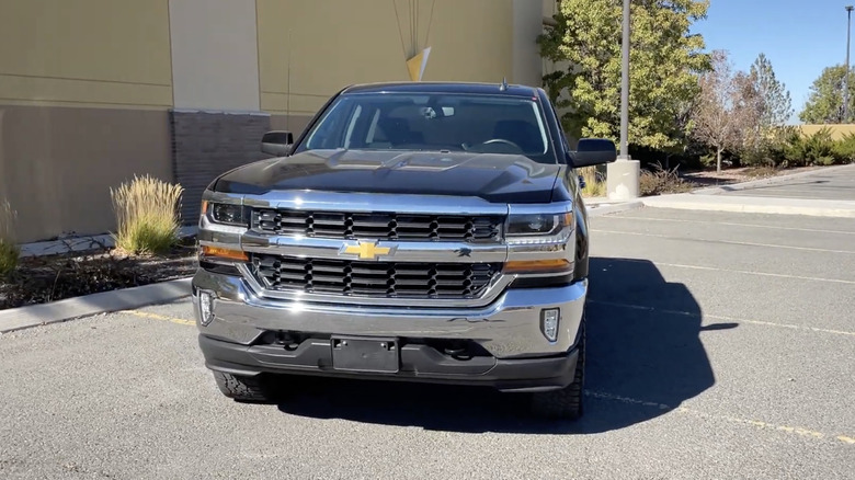 주차장에 있는 검정색 2016 Chevy 1500 LT
