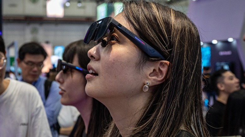 Computex 2026에서 ROG XBOX Ally X20과 페어링된 ROG XREAL R1 Edition 20 Gaming AR 안경을 확인하는 참석자
