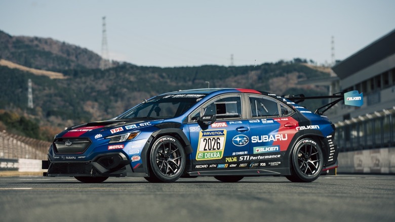 경주 트랙에 주차된 2026 Subaru WRX STI 경주용 자동차의 전면 3/4 뷰.