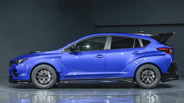 스튜디오에 주차된 파란색 2025 Subaru Performance-B STI 컨셉의 측면 모습.