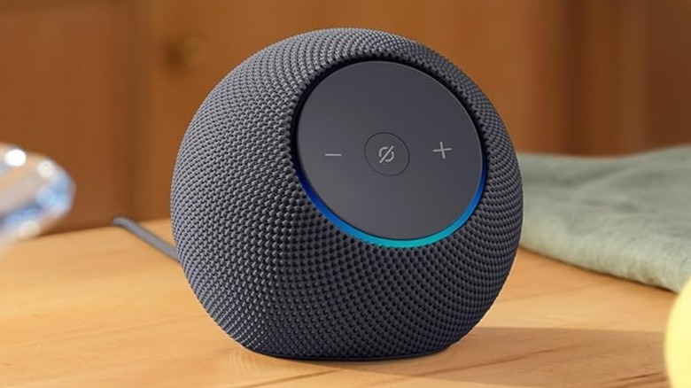 녹색 천 옆에 있는 나무 테이블 위의 Amazon Echo Dot Max
