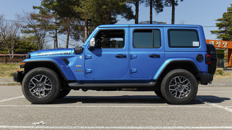 주차장에 주차된 파란색 Jeep Wrangler 4xe의 측면 모습.