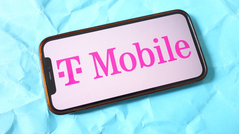 파란색 배경에 분홍색 T-Mobile 로고가 있는 스마트폰 사진