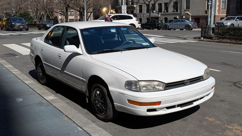 흰색 1994년식 Toyota Camry가 도시의 길가에 주차되어 있습니다.