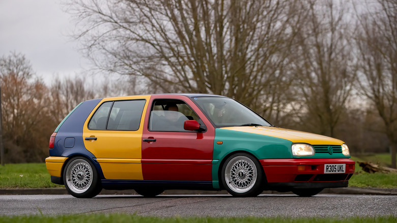 1990년대 다양한 색상의 VW Golf Harlequin이 도로에 주차되어 있습니다.