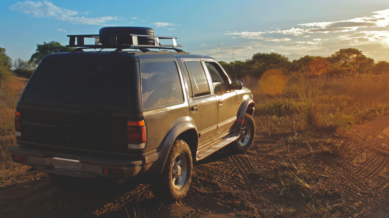 1997년형 Ford Explorer SUV가 태양을 배경으로 오프로드에 주차되어 있습니다.