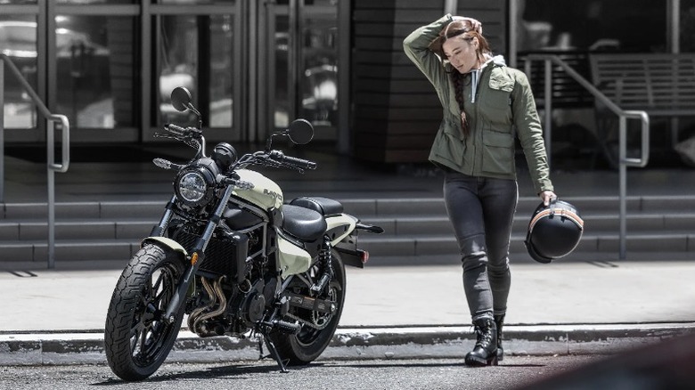 주차된 Kawasaki Eliminator 옆에 헬멧을 들고 있는 라이더